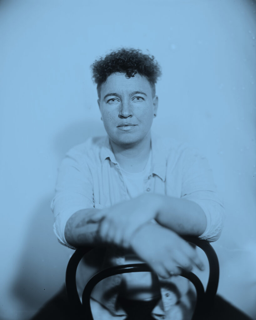 Queere Person in authentischer Pose, Regenbogenfarben, Kollodium Nassplattenfotografie, Ausstellung SEIN, LGBTQ+ Fotokunst Linz.